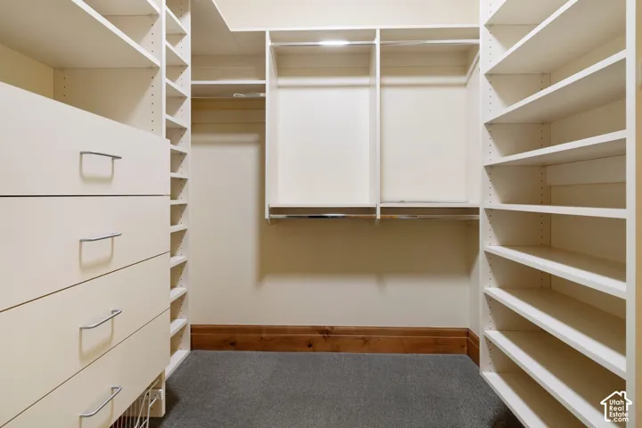 Custom closet system featuring multiple shelves, integrated drawers with metal pulls, and hanging rods