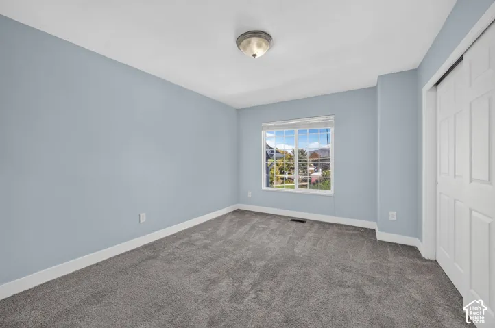 Wall-to-wall carpeting, a multi-pane window, and a sliding door closet