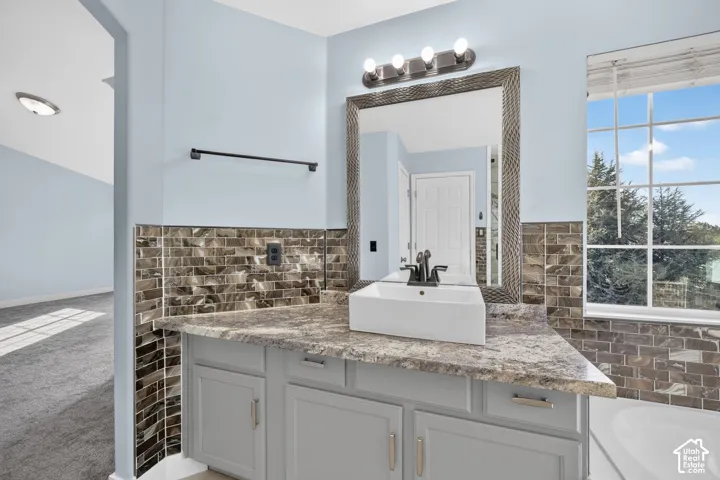 Vanity with a rectangular vessel sink, gray cabinetry, patterned countertop, and full-length mirror