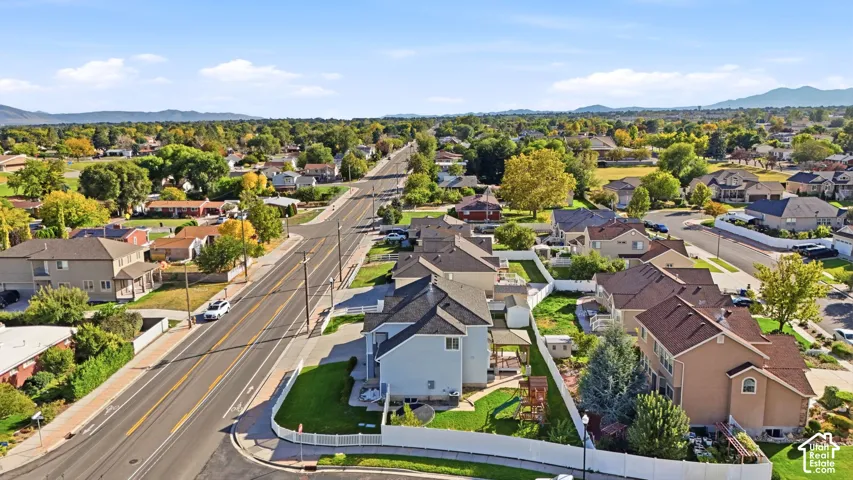 Expansive neighborhood setting with established homes, mature trees, and mountainous terrain in the distance