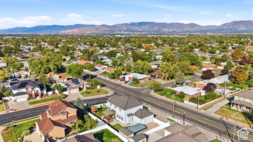 Residential neighborhood with mature trees, established properties, and distant mountain scenery