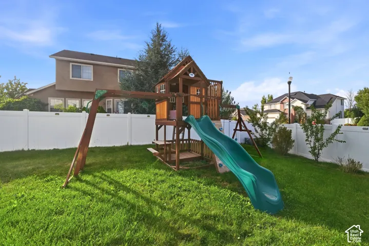 Expansive green lawn with a white privacy fence