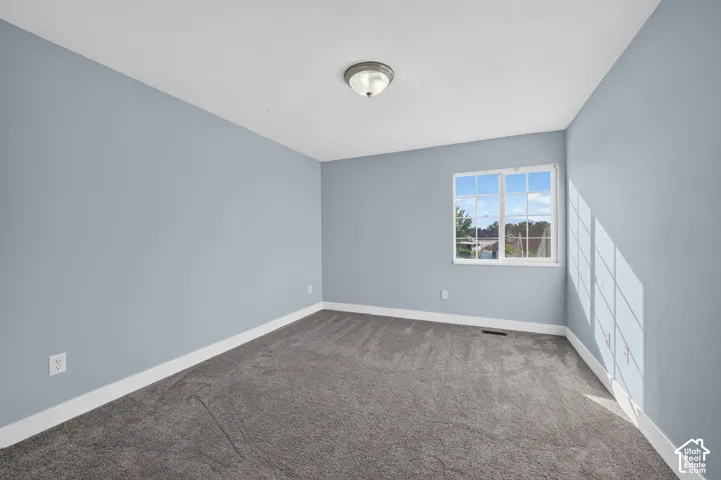 Soft gray carpeting, light blue walls, and a white-framed window