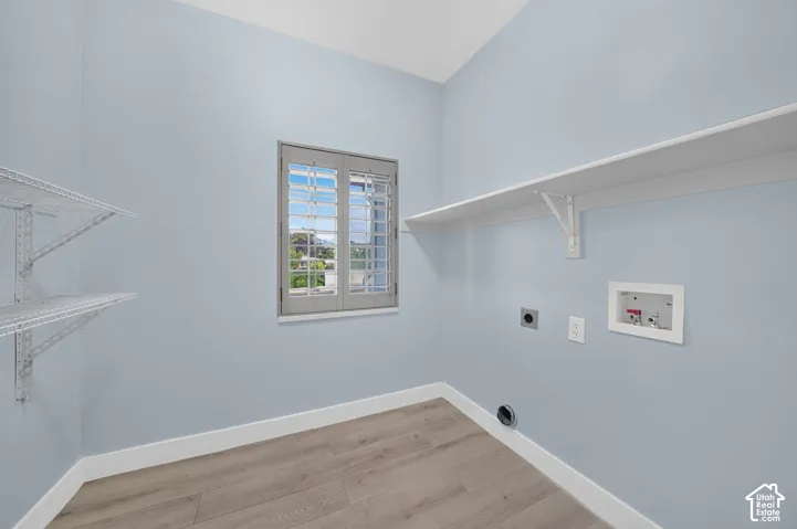 Window with louvered shutters, wood-finish flooring, single overhead shelf, and wire shelving system