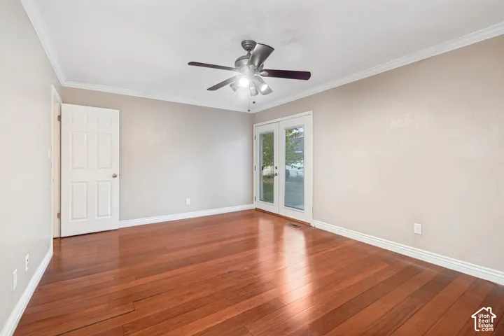 Hardwood flooring, crown molding, ceiling fan, white trim, and French doors