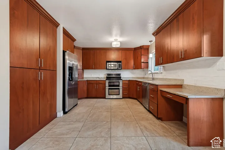 Kitchen featuring extensive cherrywood cabinetry, beige tile flooring, light-toned countertops, subway tile backsplash, and stainless steel appliances
