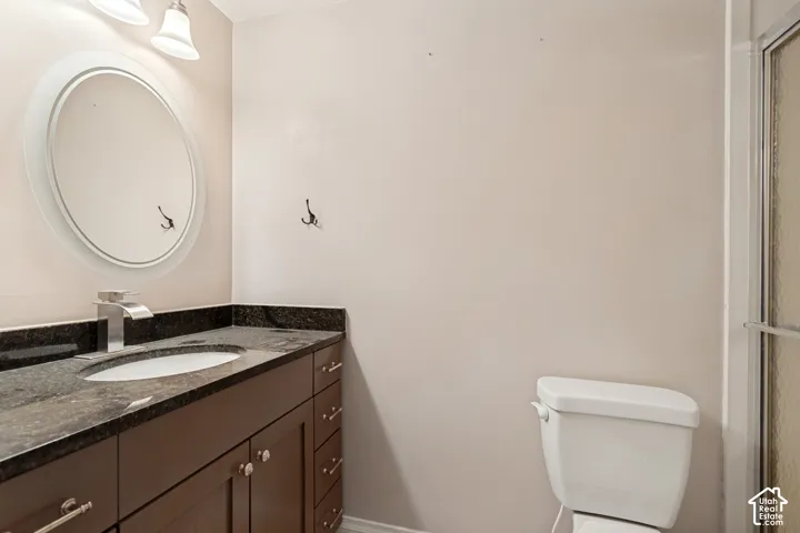 Bathroom vanity featuring a dark stone countertop, undermount sink, and a contemporary chrome faucet