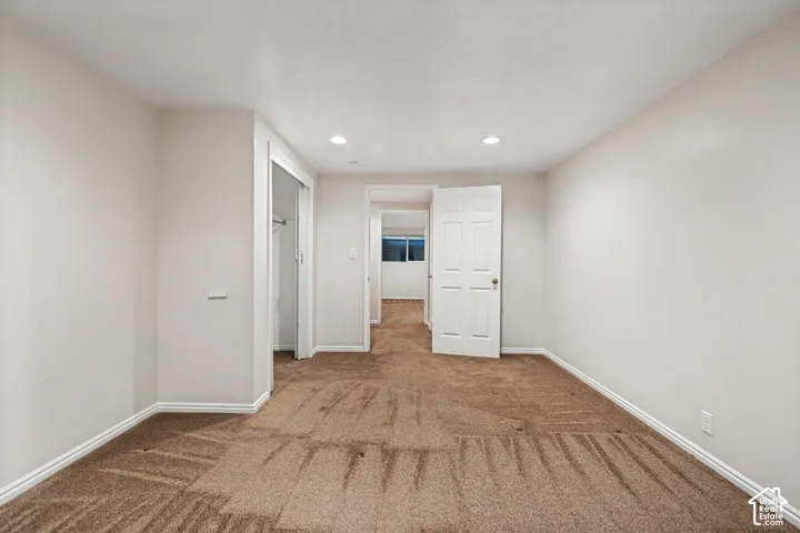 Wall-to-wall carpeting, recessed ceiling lights, and a paneled interior door