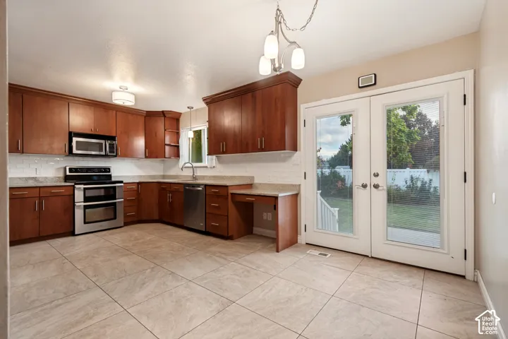 Full kitchen featuring wood cabinetry, stainless steel appliances, and a tiled backsplash