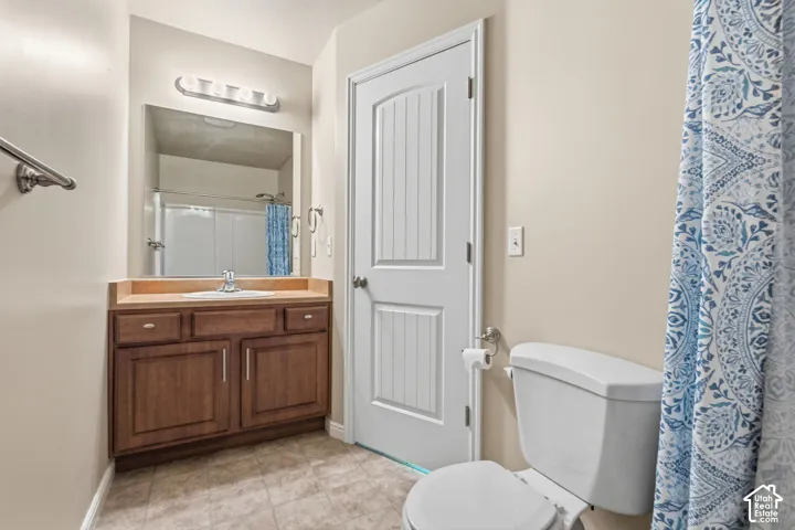 In room Bathroom for second bedroom with a wood-finish vanity, light-toned countertop, and a built-in sink