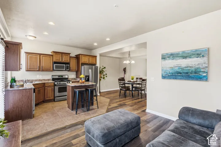 Kitchen featuring stainless steel appliances, wood-finish cabinetry, and a central island with seating