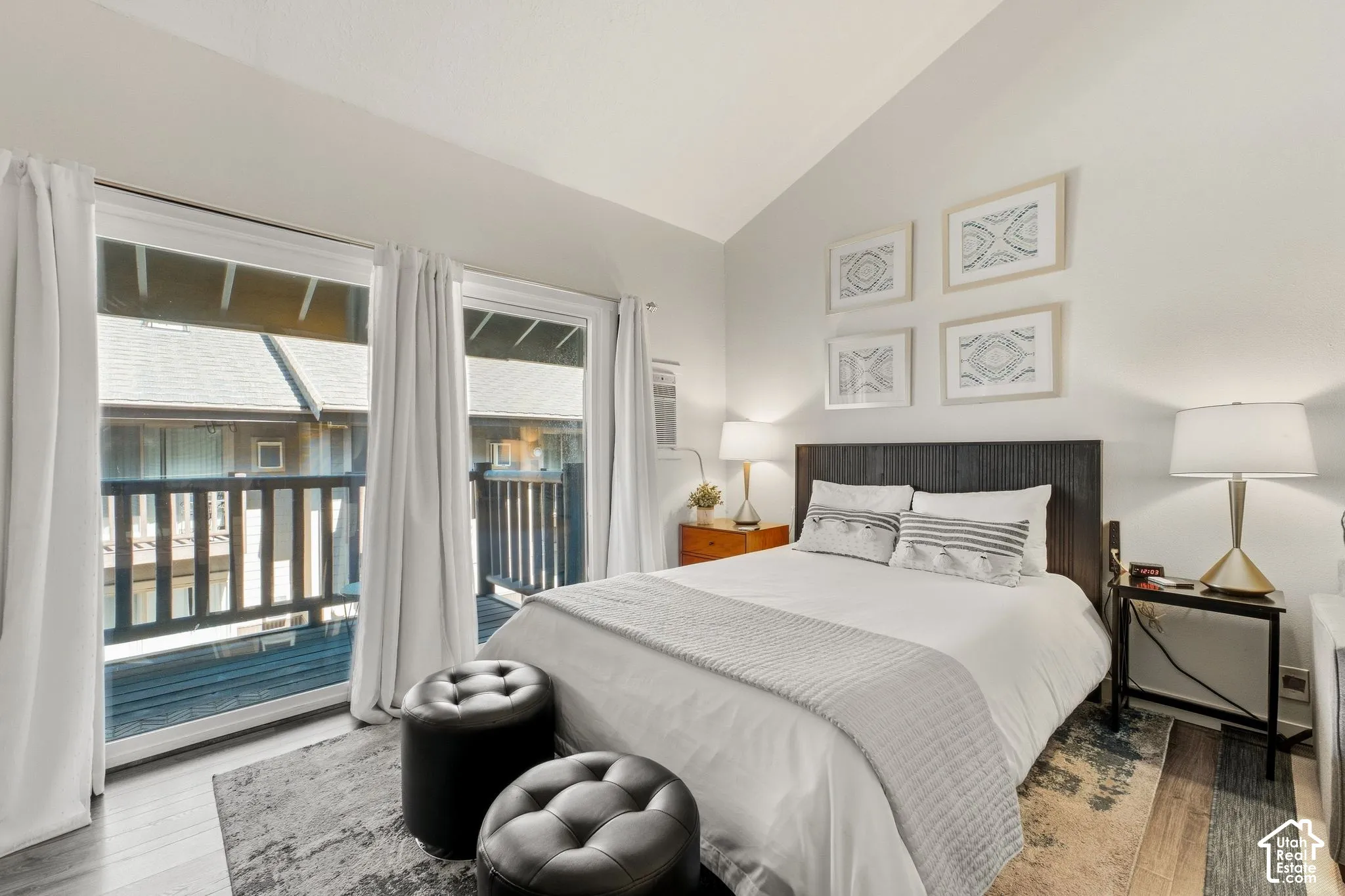 Vaulted ceiling, wood-finish flooring, two sliding glass doors, built-in headboard, and recessed lighting