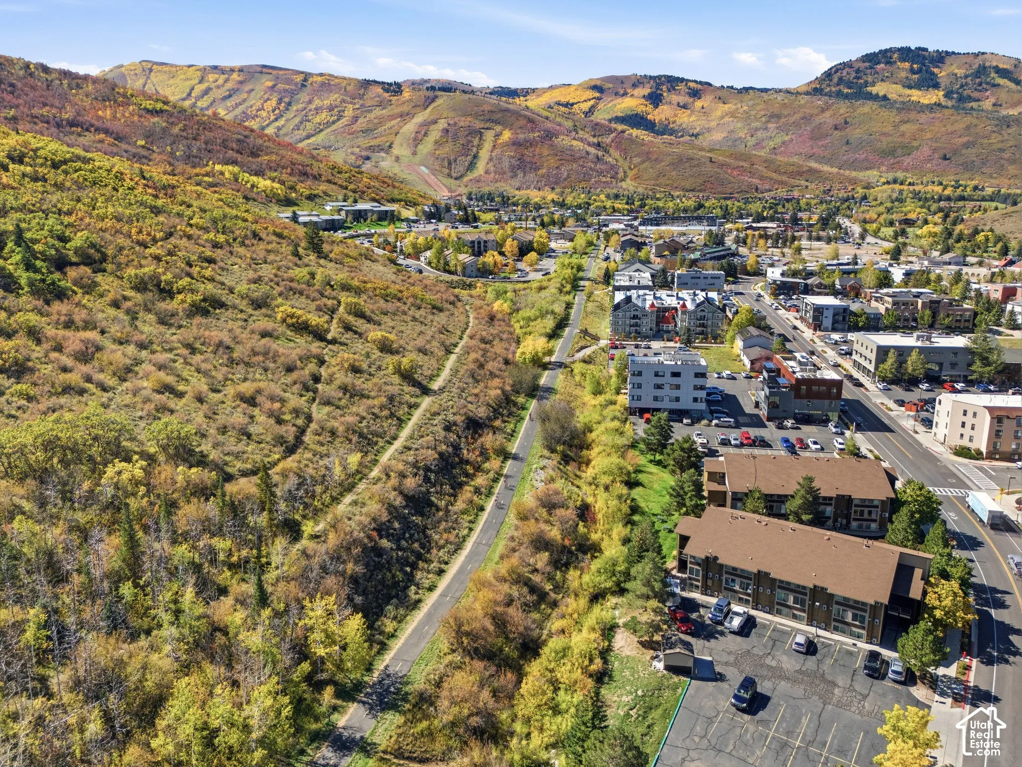 Mountainous backdrop, commercial buildings, paved roadway, structured parking areas, varied architectural styles