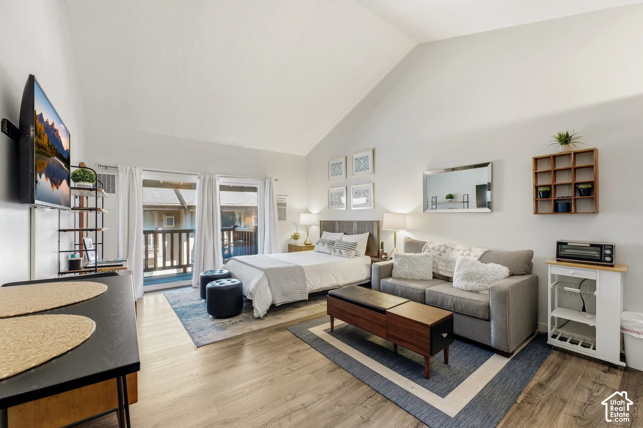 Vaulted ceiling, wood-finish flooring, and a private balcony