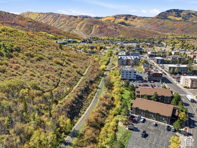 Mountainous backdrop, commercial buildings, paved roadway, structured parking areas, varied architectural styles