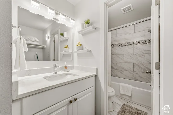 White vanity with a single basin sink, chrome faucet, and integrated countertop
