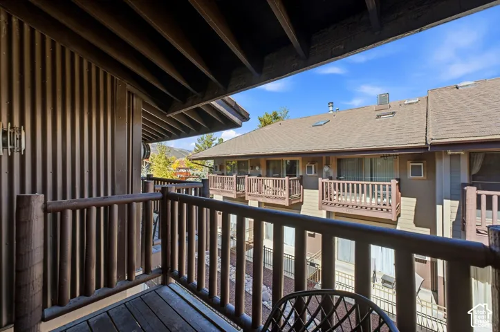 Wood-finish balcony with log-style railings and an overhead wood-plank ceiling