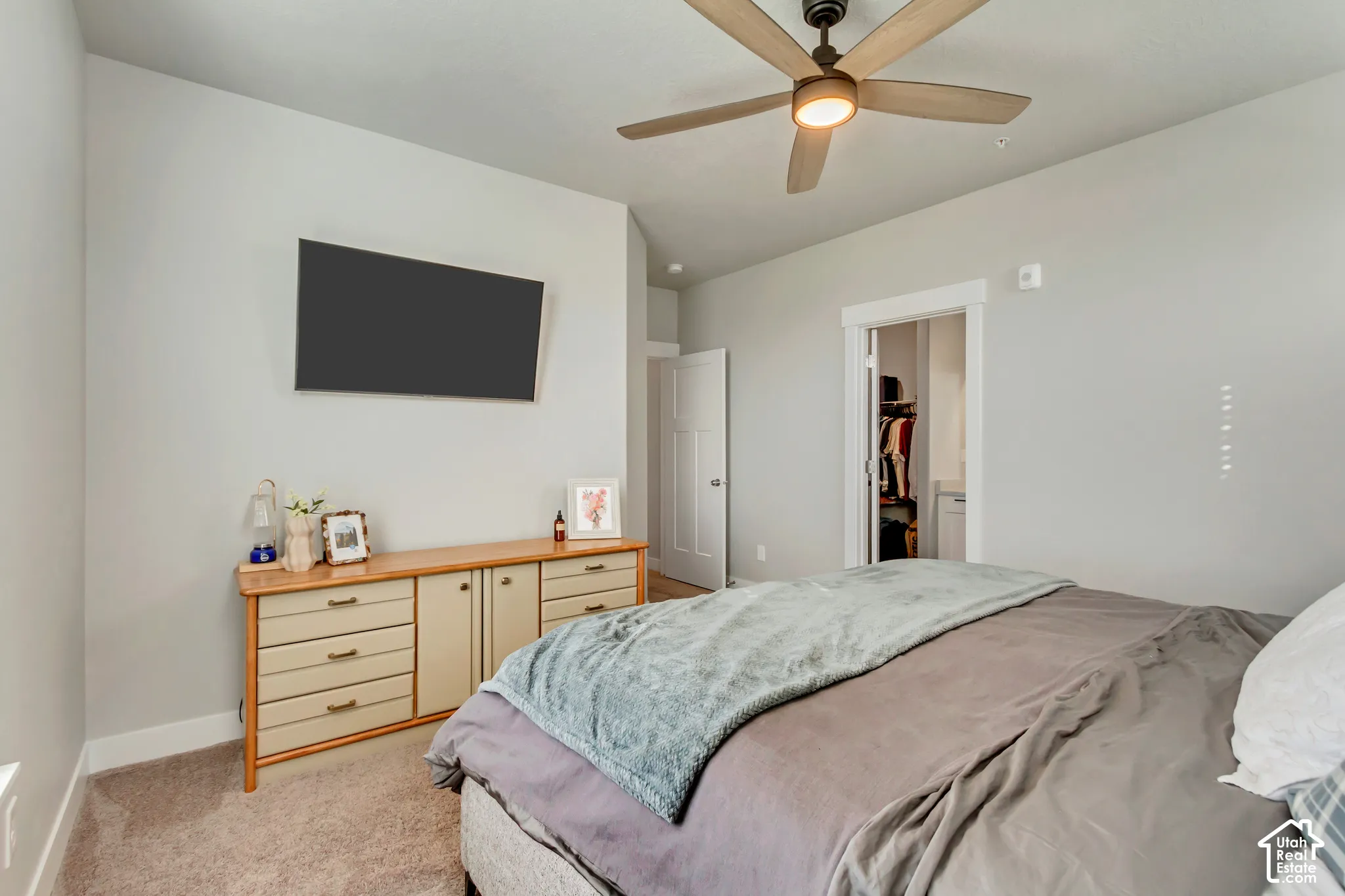 Recessed lighting, wood-finish ceiling fan with integrated lighting, carpeted flooring, and a white paneled door
