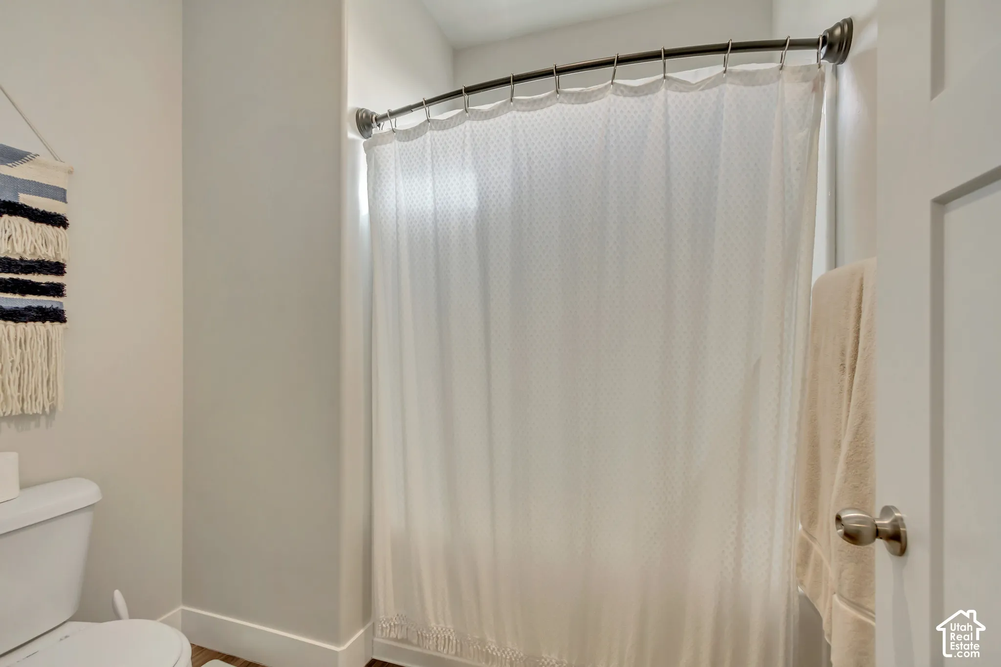 White toilet and a curved shower rod