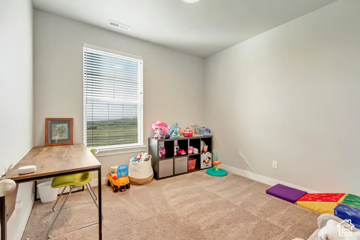 Recessed lighting, neutral wall tones, carpeted flooring, and a large window with blinds