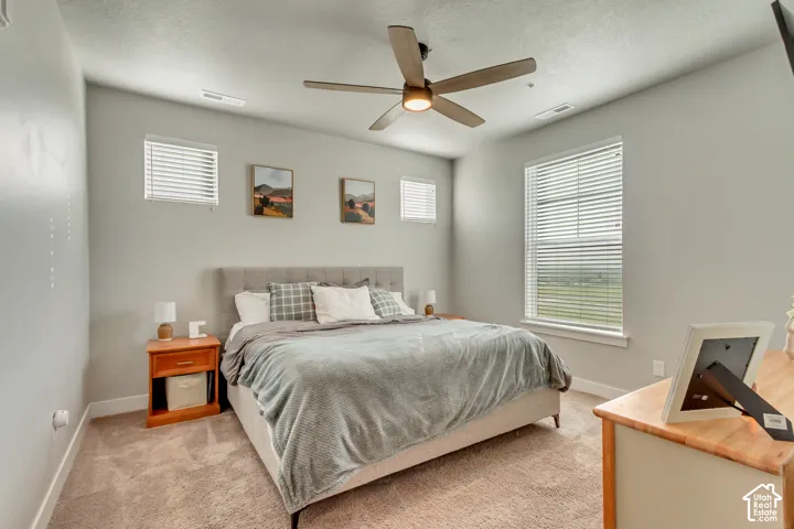 Recessed lighting, ceiling fan with integrated lighting, multiple windows with blinds, and light-toned carpeting