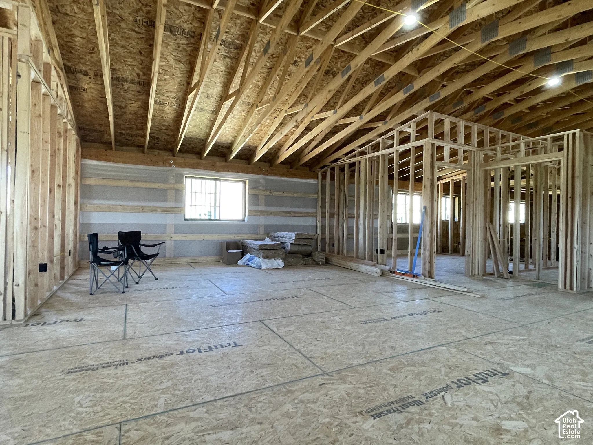 New construction framing with exposed wood trusses and subflooring