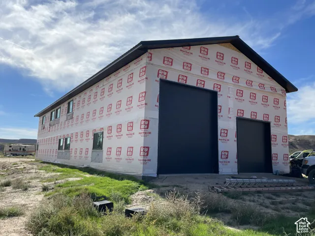 Building under construction featuring a black metal roof. Front and north side of house