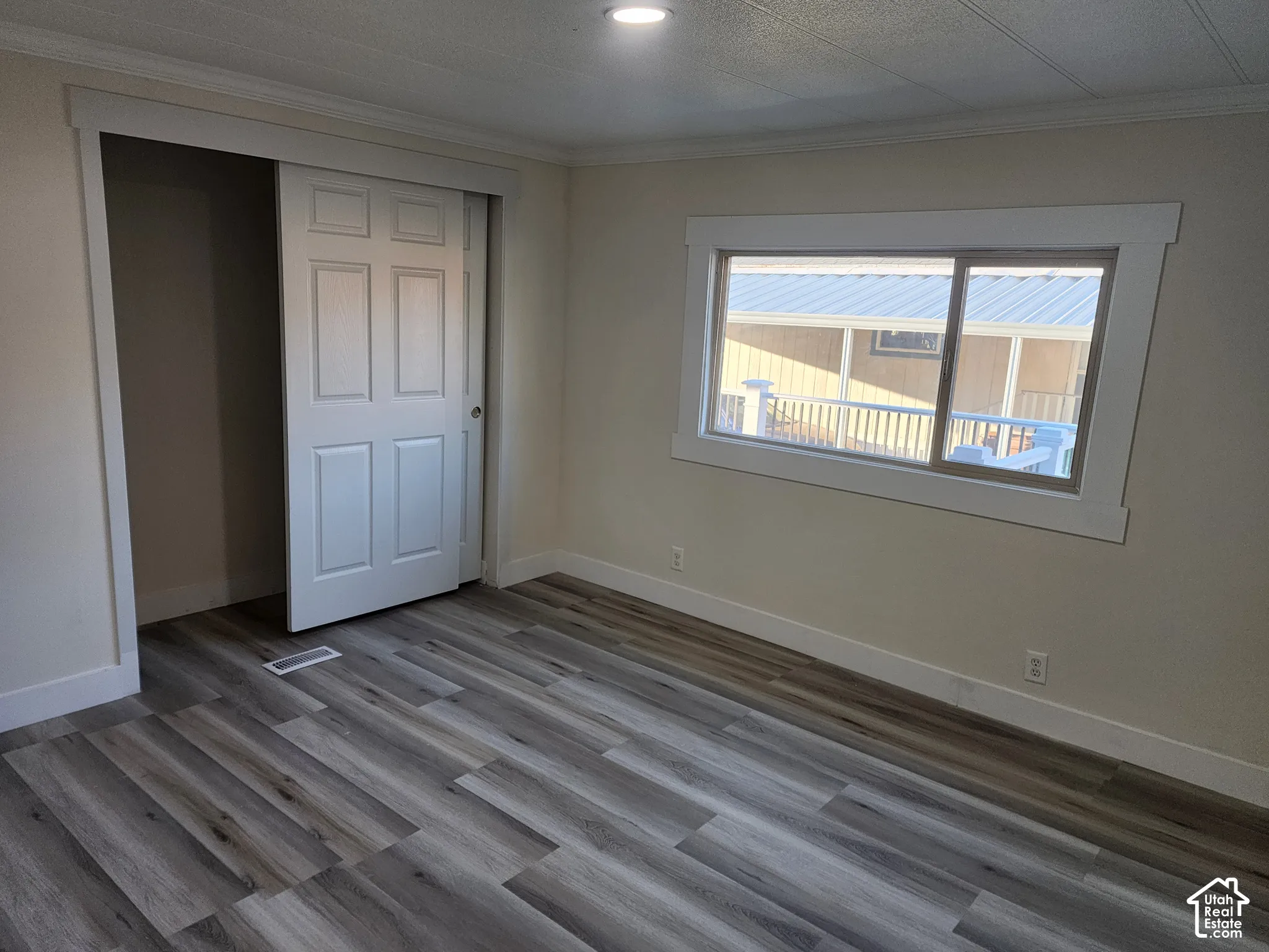 Wood-finish flooring, white trim, recessed lighting, and a sliding closet door