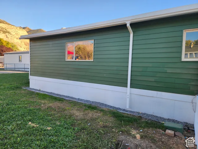Green horizontal siding with white trim and a white foundation