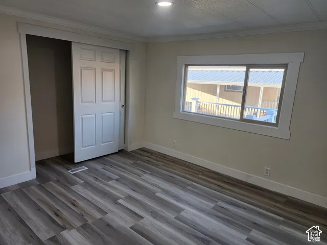 Wood-finish flooring, white trim, recessed lighting, and a sliding closet door
