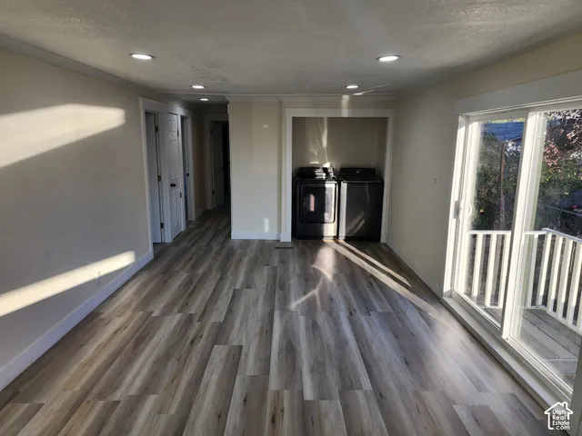 Wood-finish flooring, recessed ceiling lighting, and a sliding glass door to an exterior balcony