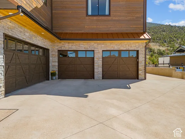 Stone veneer and wood siding exterior with three garage doors