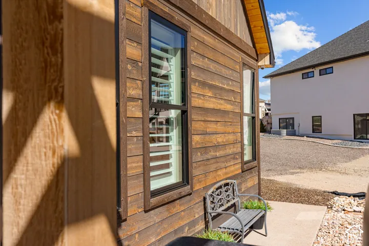 Wood-finish horizontal siding, black-framed windows, and a concrete patio