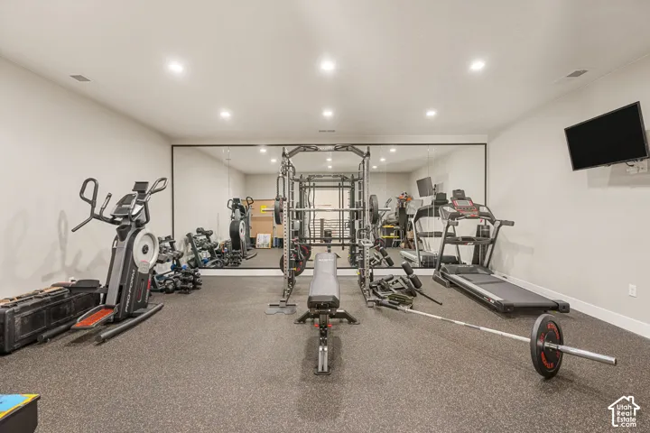 Dedicated fitness space featuring recessed lighting and a full wall mirror