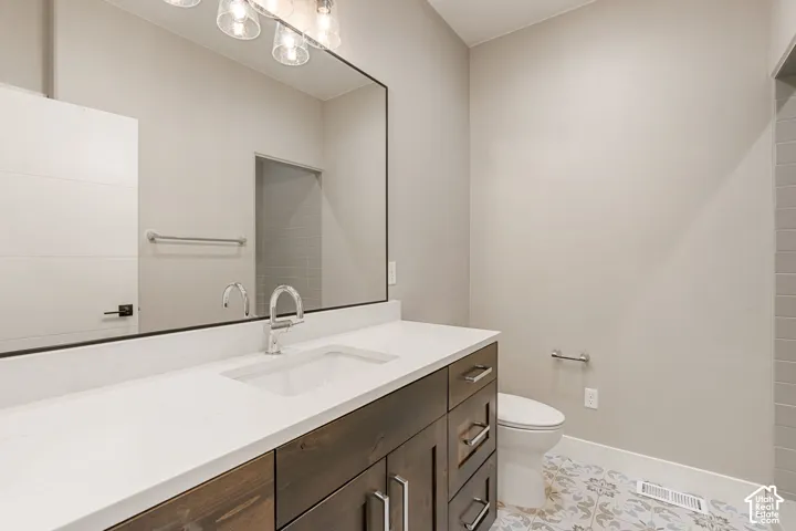 Wood-finish vanity with an integrated rectangular sink, large rectangular mirror, and an overhead vanity light fixture