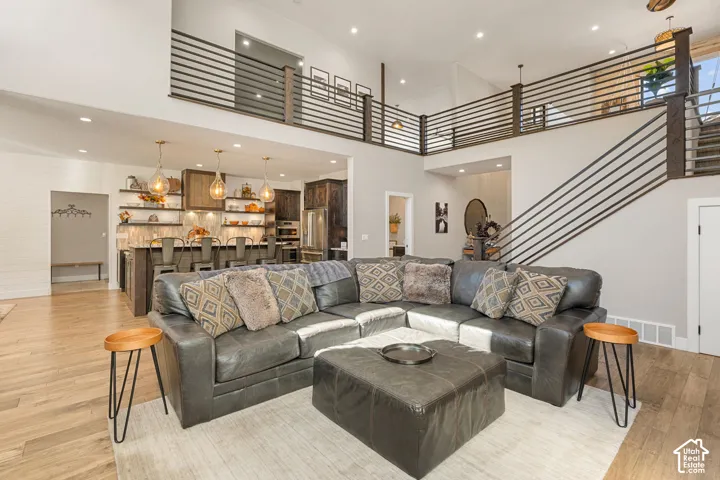 Vaulted ceilings, wood-finish flooring, and a contemporary open-riser staircase with horizontal railing