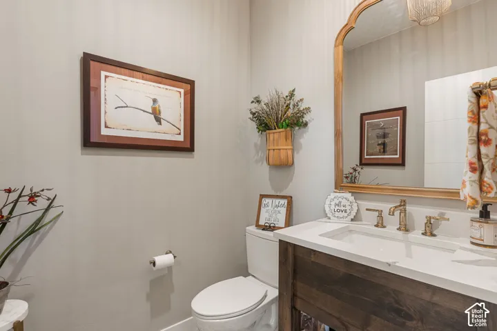 Wood-finish vanity with an integrated rectangular sink, gold-toned faucet, and a decorative mirror