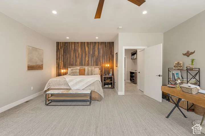 Recessed lighting, wood-finish ceiling fan, full accent wall with vertical wood paneling, wood-finish built-in shelving, carpet flooring