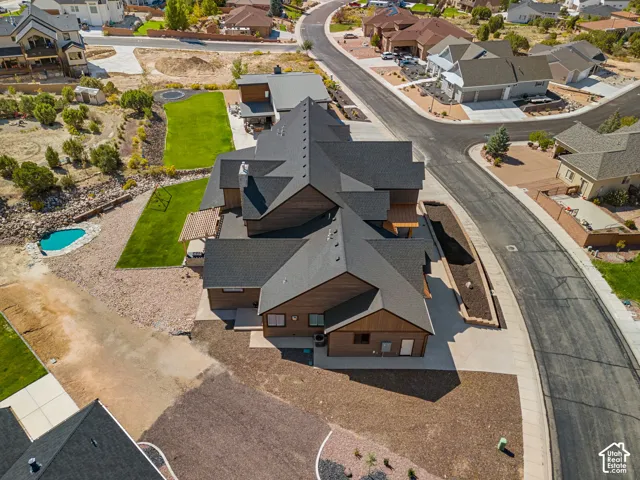 Multi-level residence featuring a dark shingle roof, wood-finish siding, and a concrete driveway