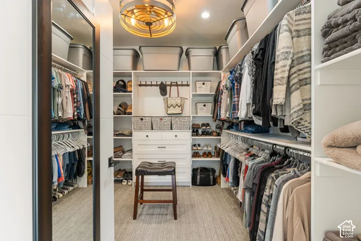 Custom built-in storage, extensive shelving, integrated hanging rods, and a central dresser unit