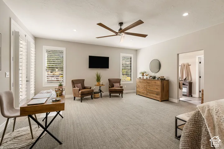 Recessed lighting, wood-finish ceiling fan, plantation shutters, and light-toned carpeting