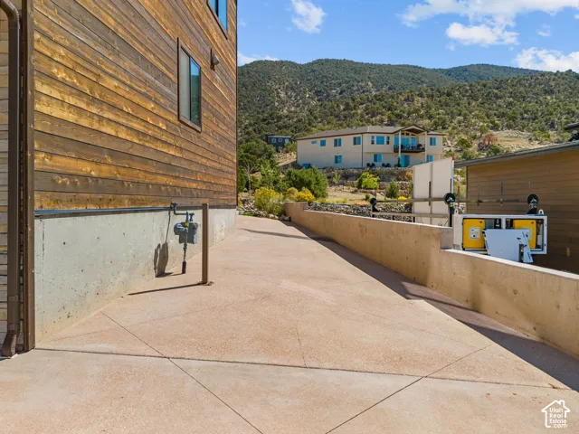 Exterior featuring wood-clad siding, a concrete foundation, and a concrete pathway with saw-cut joints