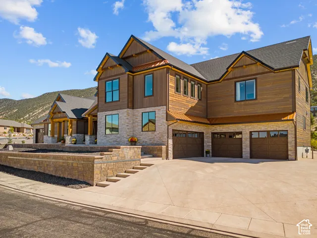 Multi-level exterior featuring wood siding, stone accents, and dark shingle roofing