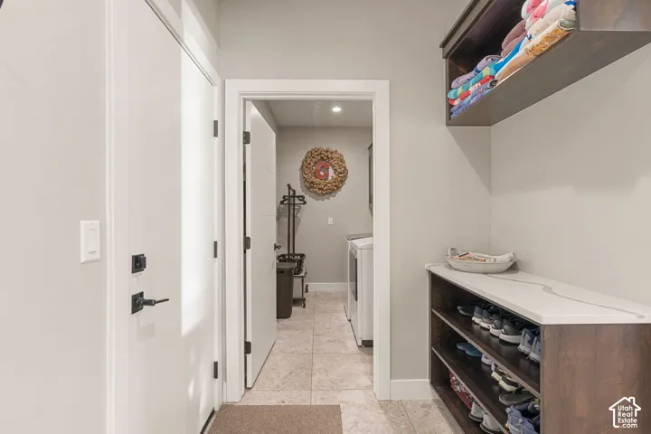 Hallway with a built-in wood-finish storage unit, white countertop, and an overhead wood-finish shelf