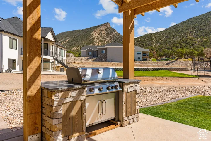 Outdoor grilling station featuring a built-in stainless steel grill, stone-clad base, and a countertop surface