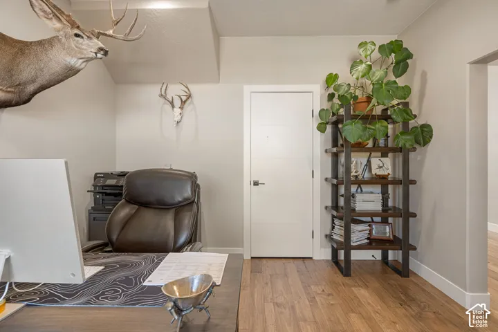 Wood-finish flooring throughout, with a solid core interior door featuring a modern black handle