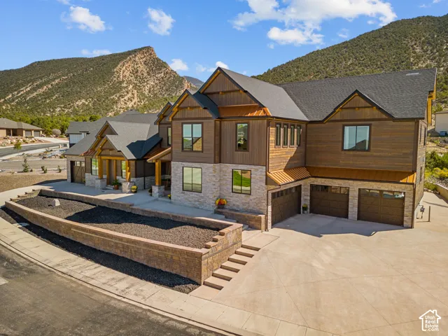 Crafted exterior featuring stone and wood-finish siding, a multi-gabled roofline, and a prominent front porch