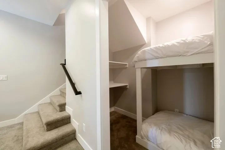 Built-in bunk beds with integrated shelving and carpeted flooring