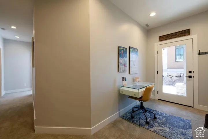 Recessed ceiling lighting, full-light exterior door, and a built-in floating desk