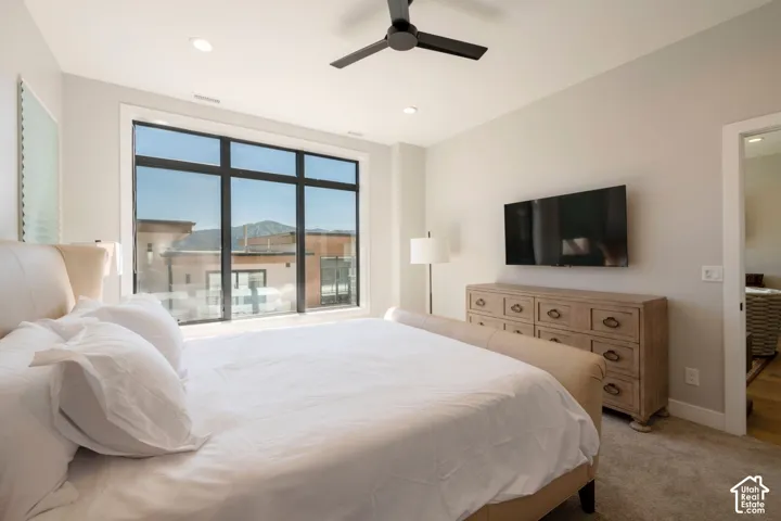 Expansive window with mountain scenery, recessed lighting, and a modern ceiling fan